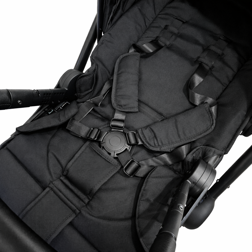 Close-up of a black stroller seat with straps on a white background