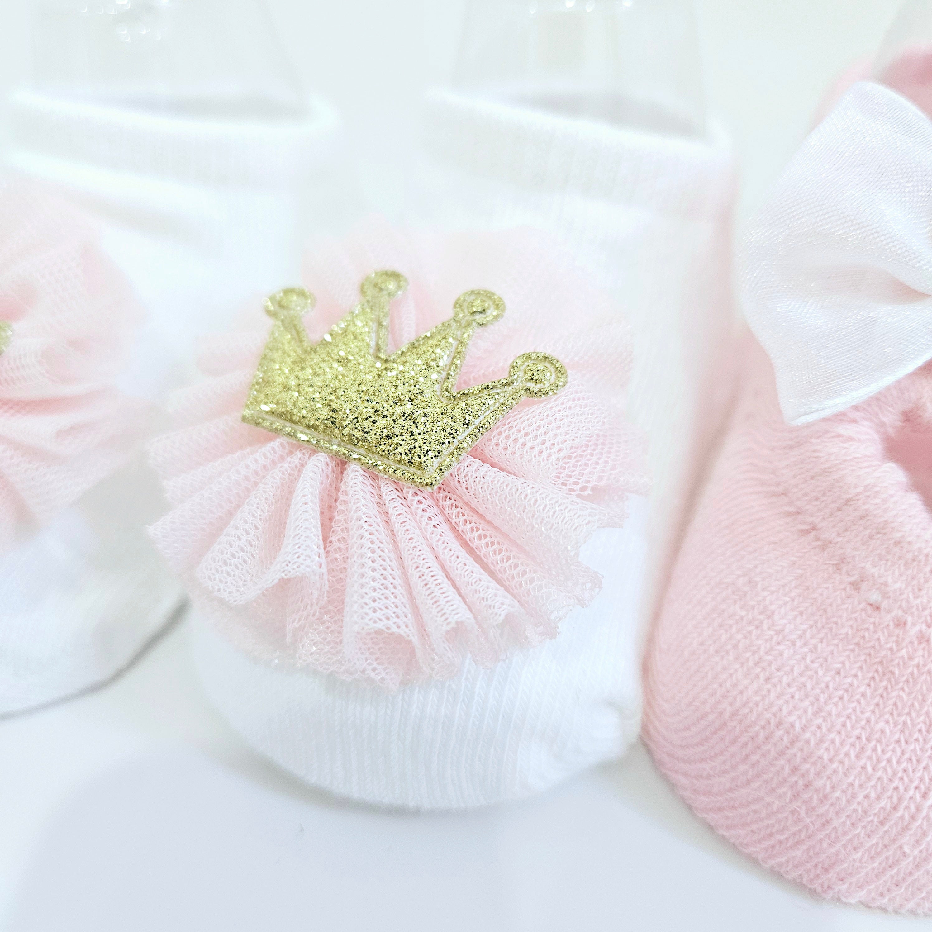 Comfortable and stylish baby girl socks in pink and white, sold as a two-pack with a cute bow and elegant crown embroidery. Perfect for newborns, infants, and toddlers
