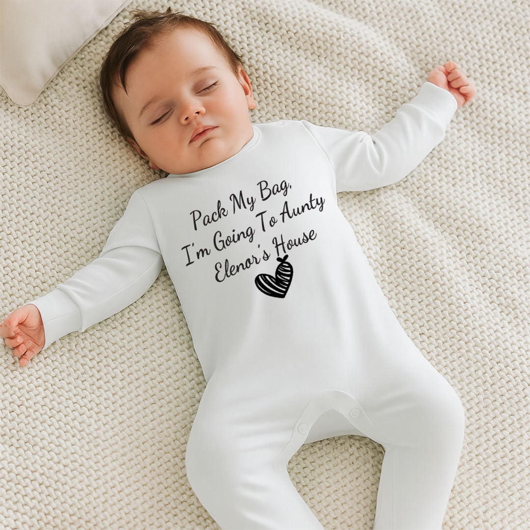 Baby wearing a white onesie with text lying on a textured surface