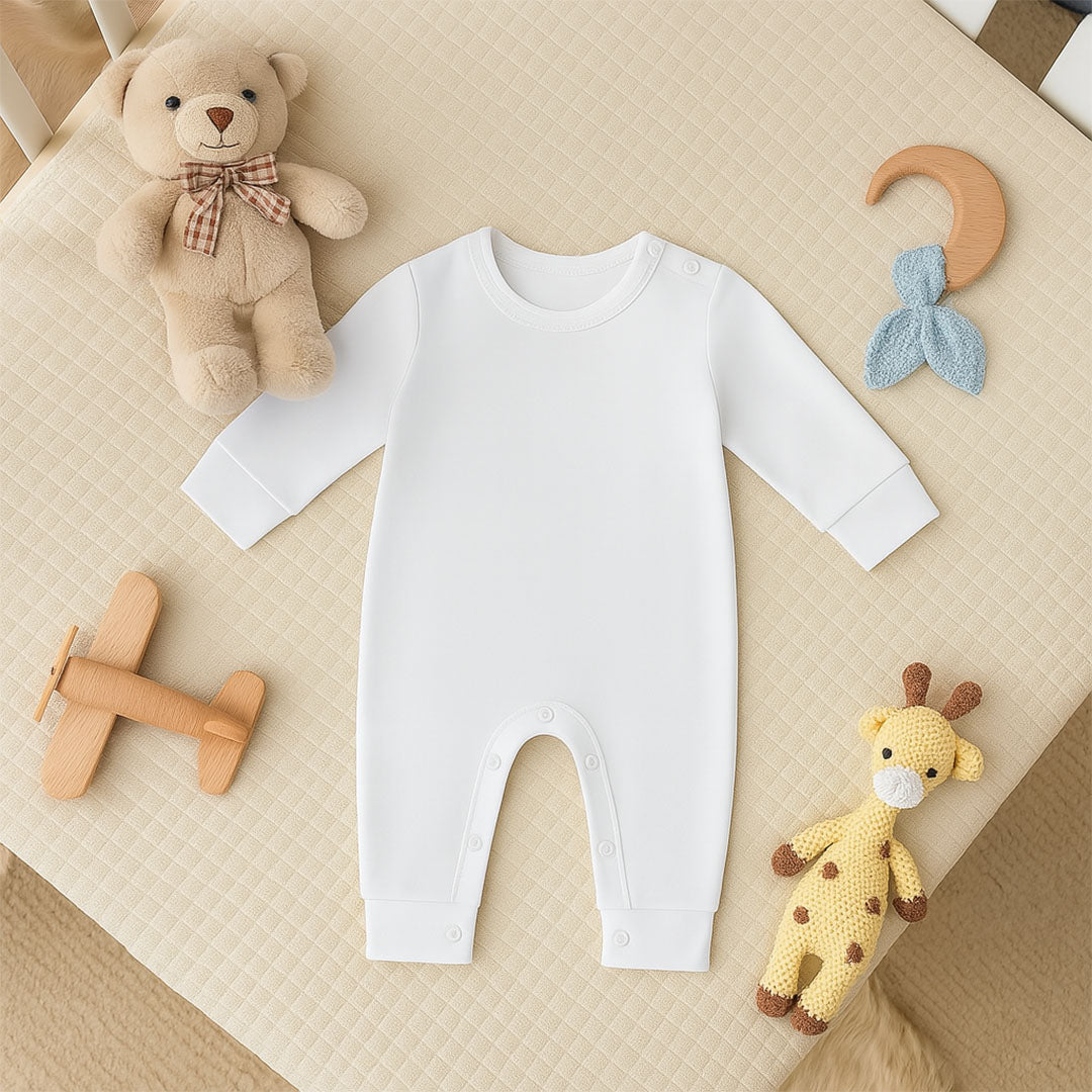 White baby onesie on a beige surface with toys around