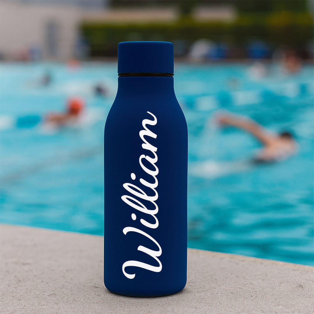 Blue water bottle with 'William' printed on it in a pool setting