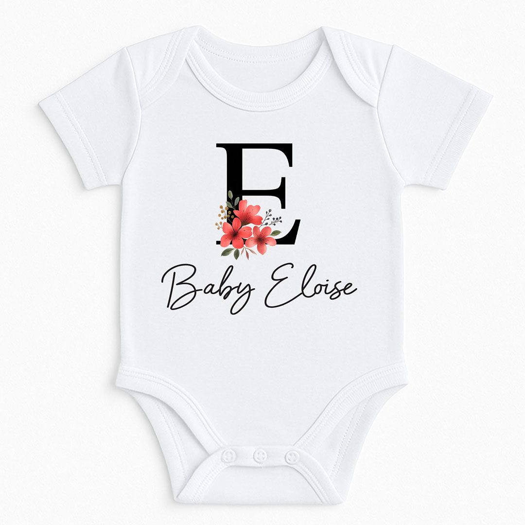 White baby onesie with a bold letter “E” and floral design, personalized with “Baby Eloise” – perfect for gifts and milestone photos.