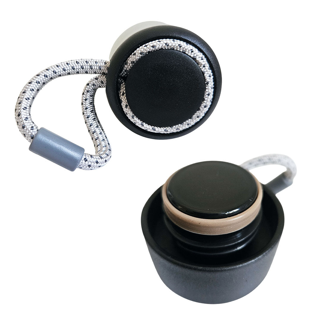 Black and gray earbud with a coiled cable on a white background