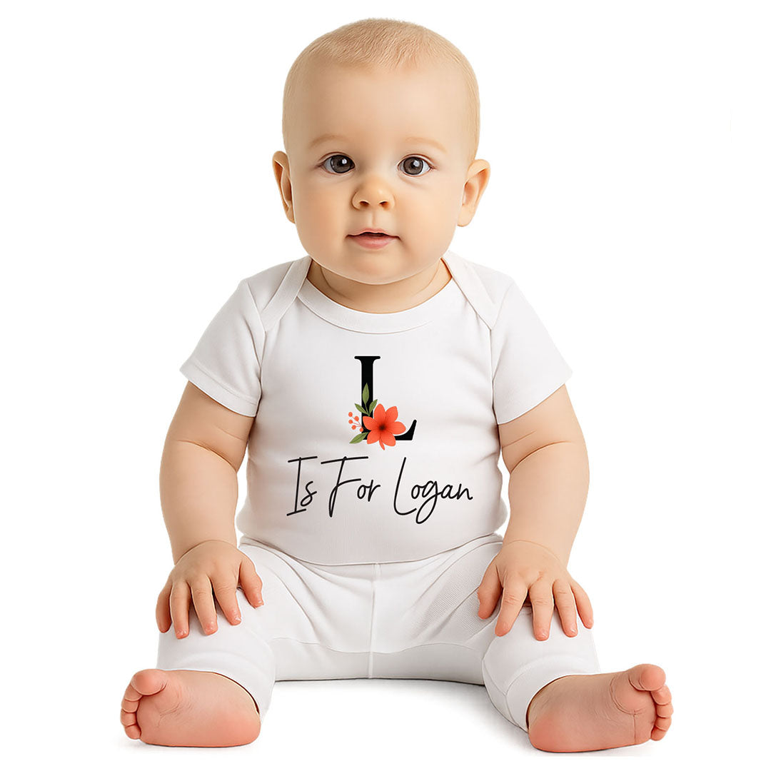 Sweet baby in a white custom onesie that says “L is for Logan” with a red flower graphic – ideal for newborn gifting and photo moments.