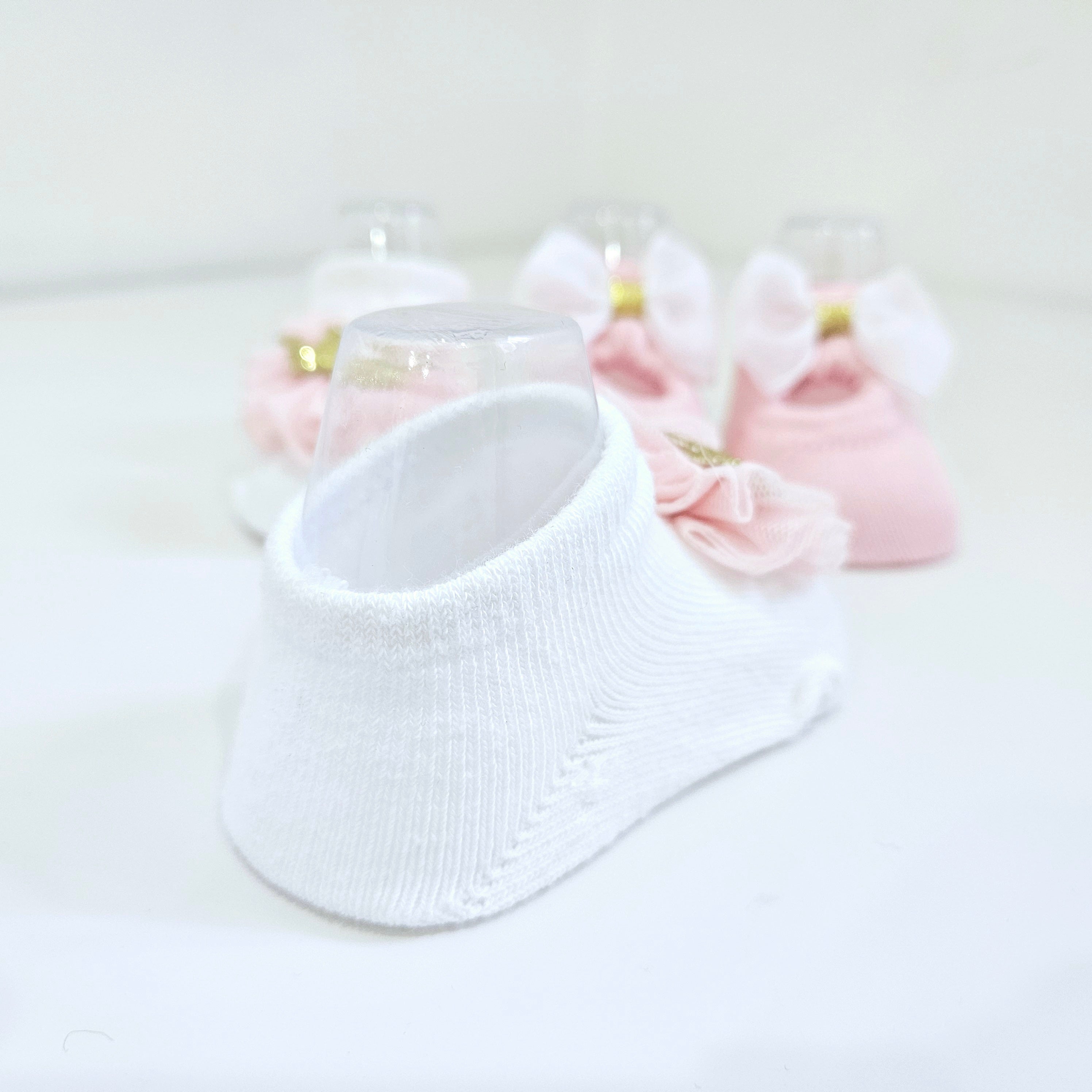 Soft cotton baby socks for newborn girls, designed in a pink and white two-pack with charming crown and bow accents. Breathable, comfortable, and perfect for baby princesses.