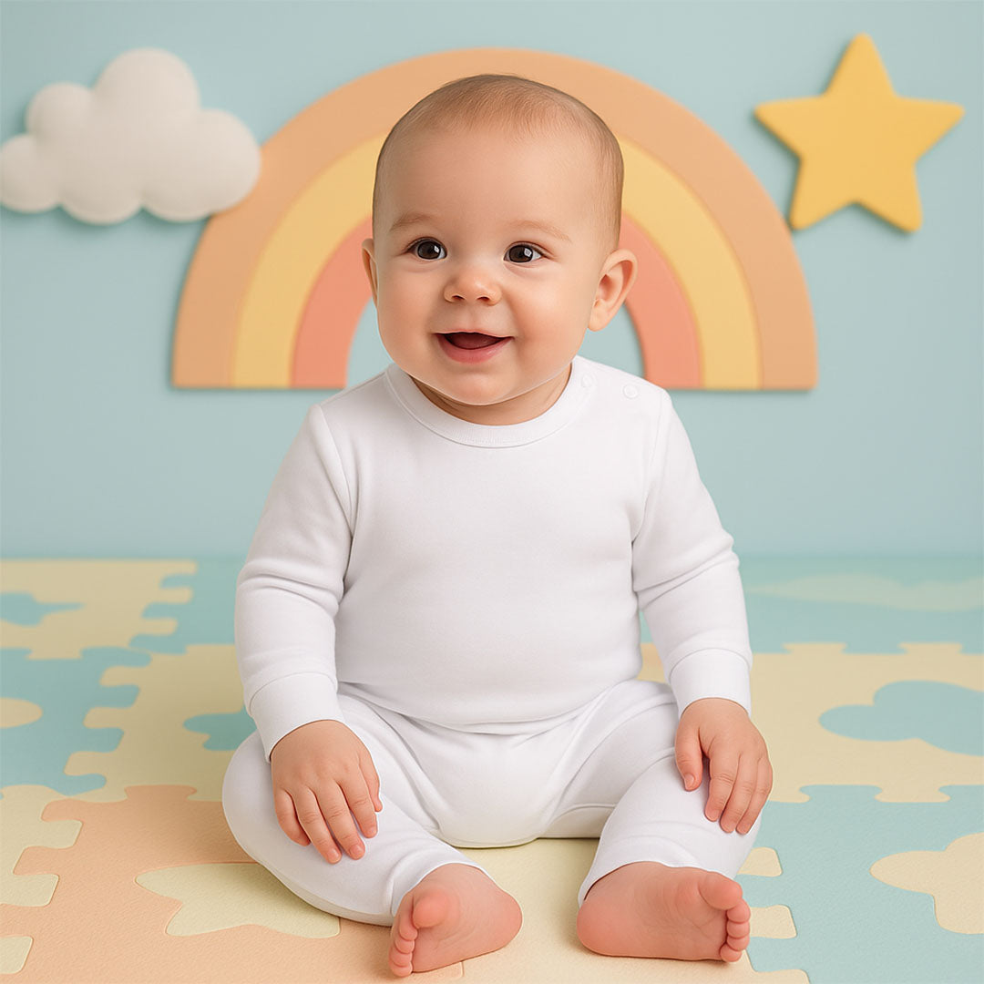 Baby in a white onesie sitting on a colorful mat with a rainbow and star in the background