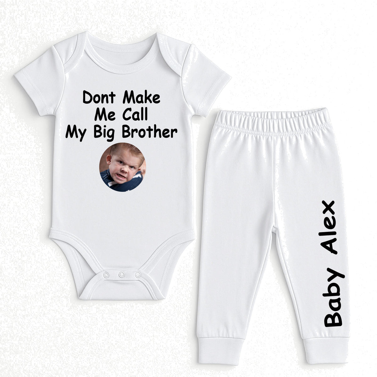 A two-piece baby outfit set consisting of a white short-sleeve bodysuit and matching jogger pants. The bodysuit features the black printed text 'Dont Make Me Call My Big Brother' above a circular photo placeholder.