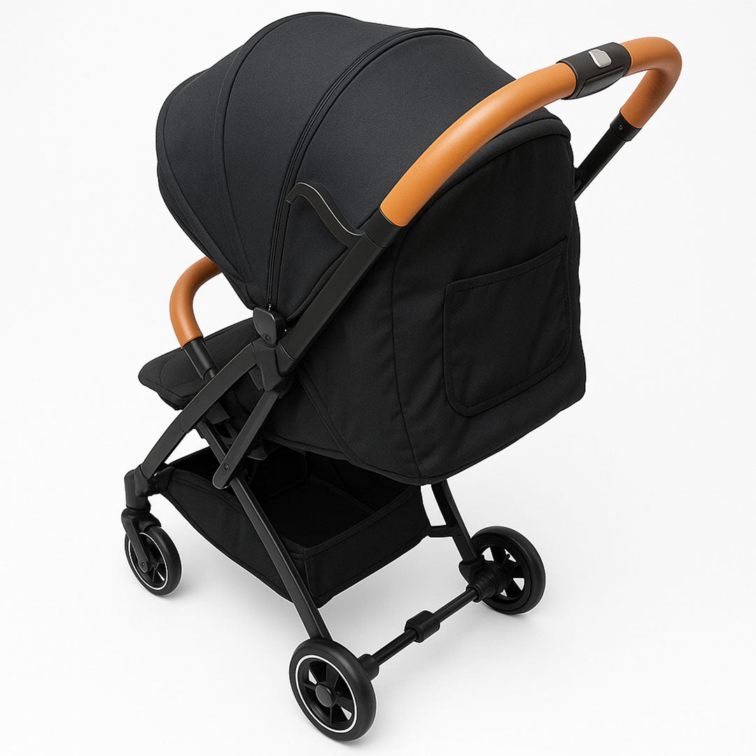 Compact baby stroller in black with tan leather handle and quilted seat – premium and foldable travel stroller for toddlers.