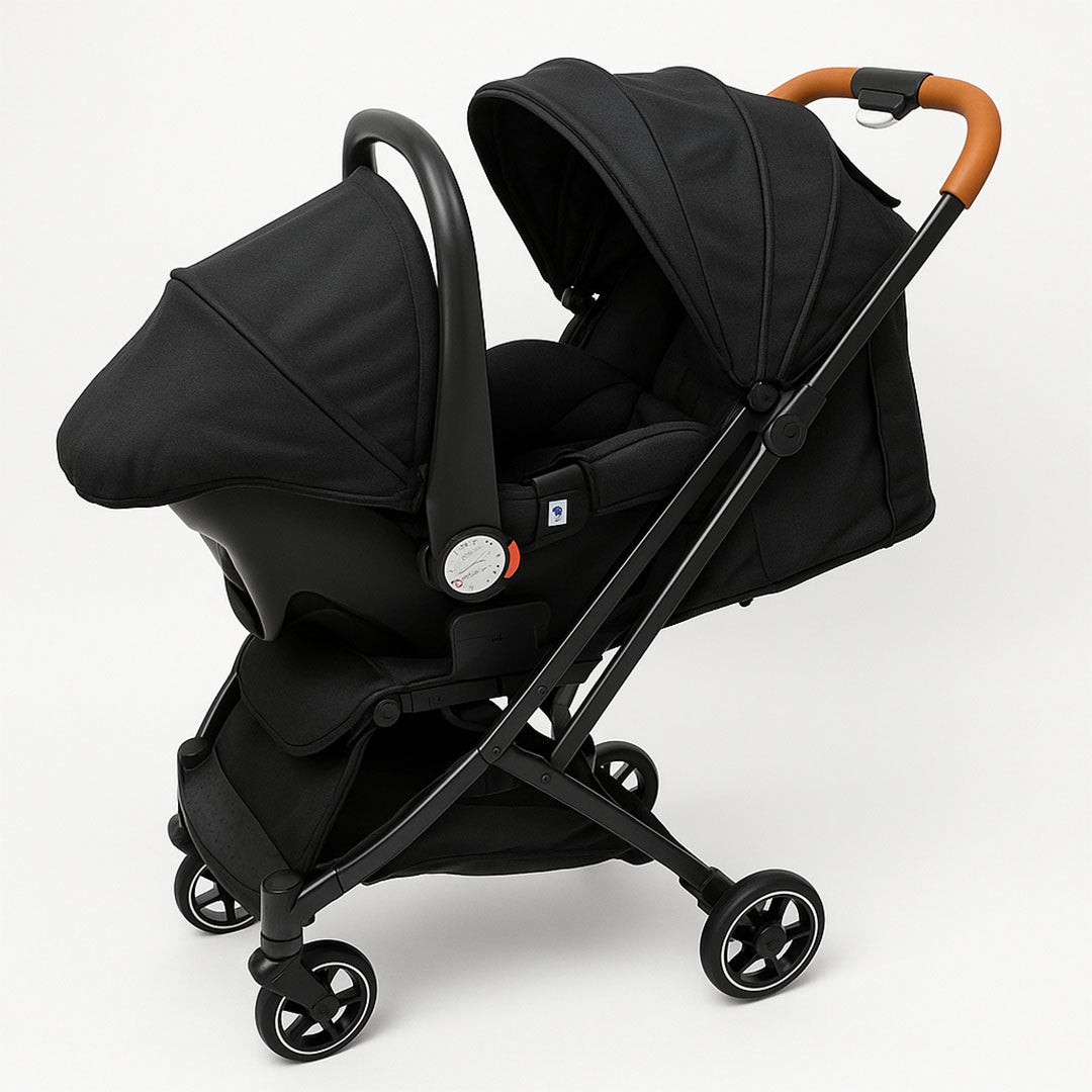 Sleek black infant car seat with ergonomic padding and safety labels – perfect for newborn travel safety and comfort.